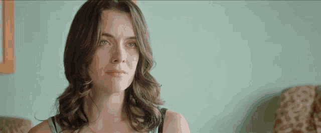 a woman is sitting in a chair and looking at the camera