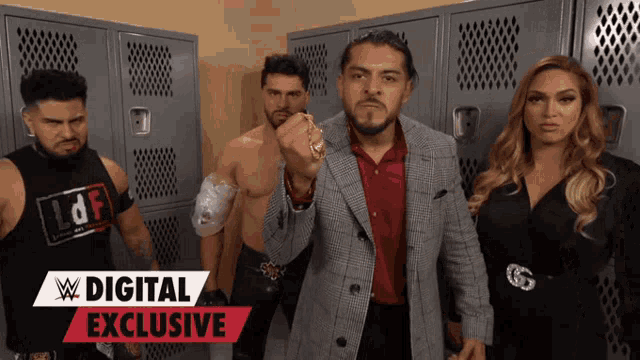 a group of wrestlers are standing in a locker room with a digital exclusive banner behind them