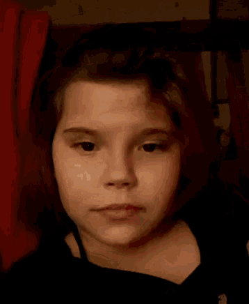 a young girl making a funny face with her hand