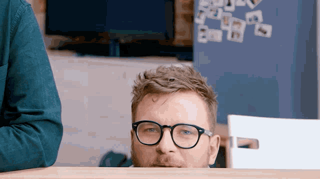 a man wearing glasses looks over a table