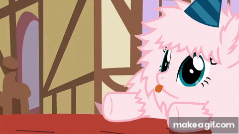 a cartoon pony wearing a party hat is sitting on a table .