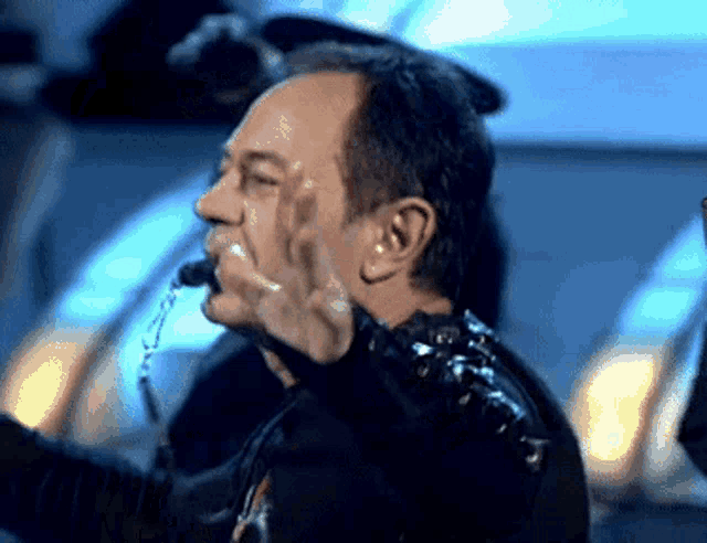 a man with a microphone in his mouth making a funny face