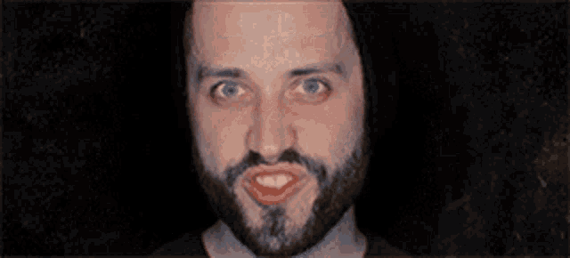 a man with a beard and blue eyes is smiling