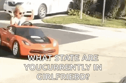 a man is driving a toy car down the street .