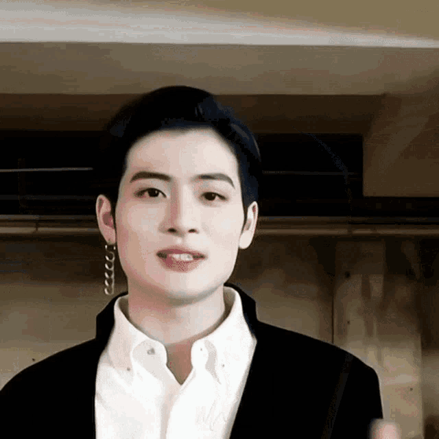 a close up of a man wearing a white shirt and a black jacket