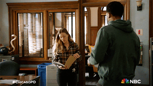 a man and a woman are standing in a room with nbc written on the bottom right