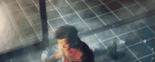 a man is standing on a tiled floor in a room with a blurred background .