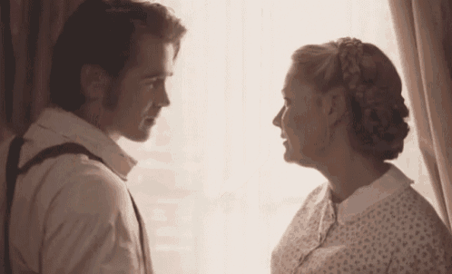 a man and a woman are looking at each other in a room