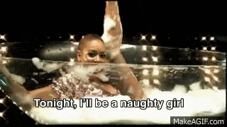 a woman is taking a bath in a glass tub with foam coming out of her mouth .