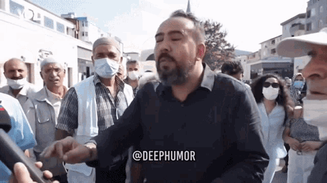 a man wearing a mask stands in front of a crowd and says deephumor on the bottom