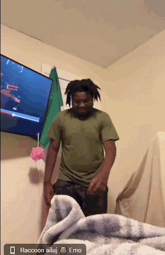 a man in a green shirt is dancing in front of a tv with raccoon ailuj emo written below him