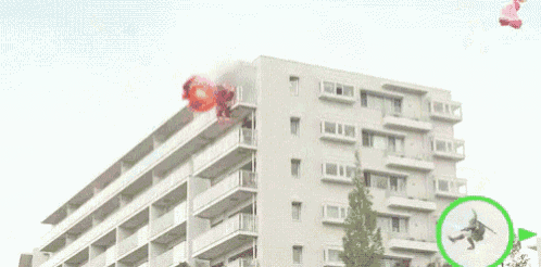 a video game character is flying through the air in front of a building with a green circle around him .
