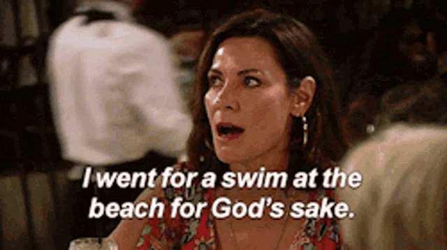a woman is sitting at a table talking about going for a swim at the beach for god 's sake