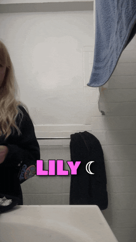 a woman standing in front of a bathroom sink with the name lily written on it