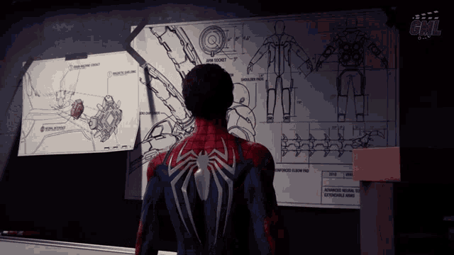 a man in a spiderman suit stands in front of a board with drawings