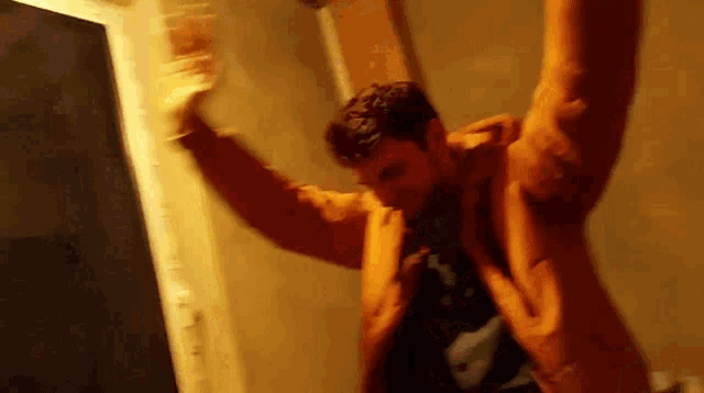 a man in an orange jacket is dancing with his arms outstretched .