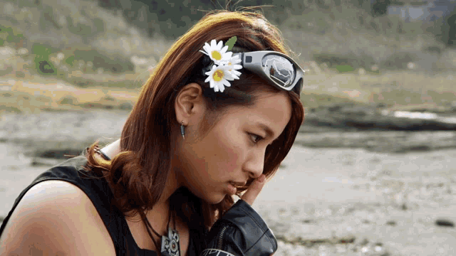 a woman wearing sunglasses has a flower in her hair that says peace on it