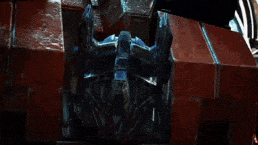 a close up of a robot 's head with a red brick background