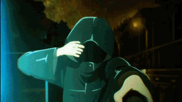 a person in a hooded jacket covering their face with their hand