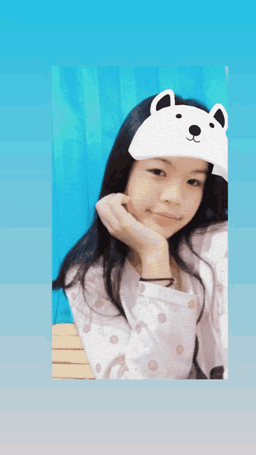 a young girl wearing a white hat with bear ears