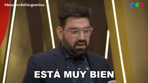 a man with glasses and a beard says " esta muy bien "