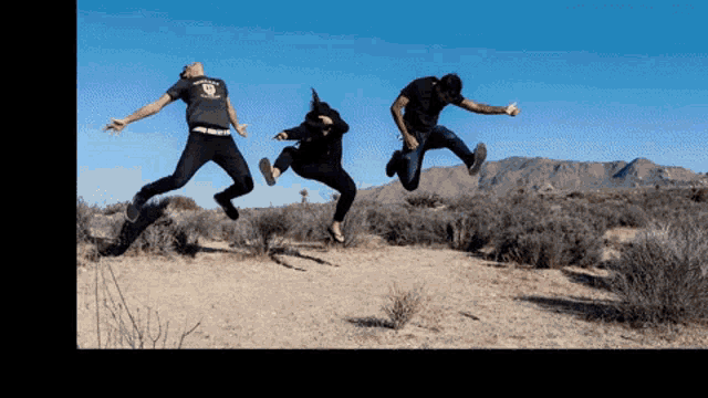 three people are jumping in the air with one wearing a t-shirt that says ' freedom '