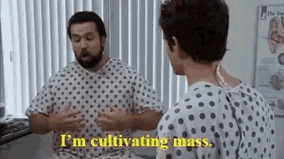 a man in a hospital gown is talking to another man .