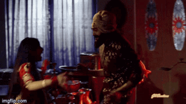 a man in a turban is standing next to a woman in a red dress with imgflip.com in the corner