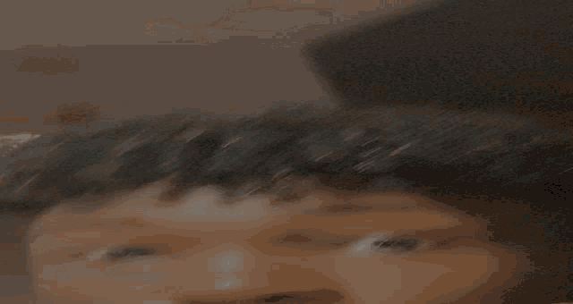 a close up of a person 's face with a candle behind them