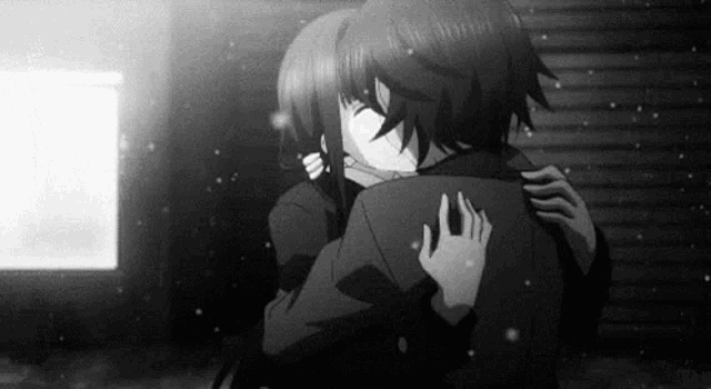 a black and white photo of a boy and a girl hugging each other .