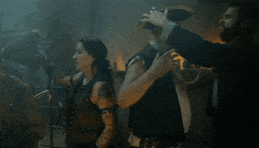 a man in a pirate hat talks to a woman in a dark room