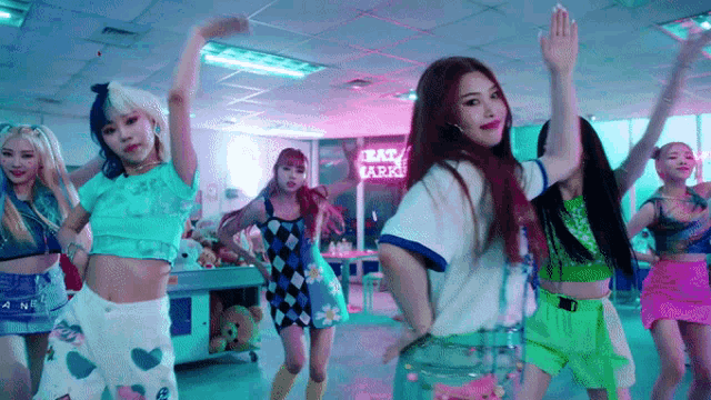 a group of girls are dancing in a room with a sign that says lucky mark