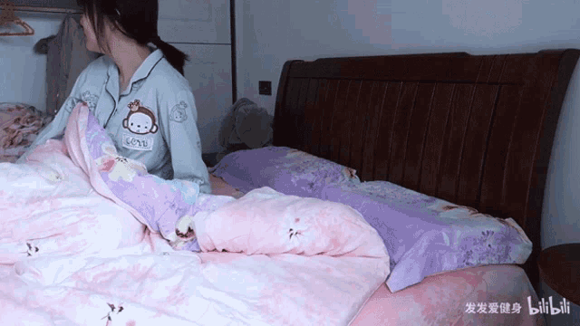 a girl is laying on a bed with a monkey on her shirt that says love