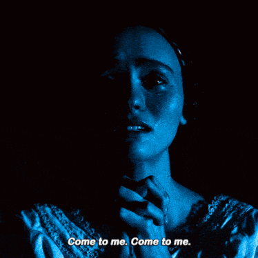 a woman in a dark room with the words come to me come to me
