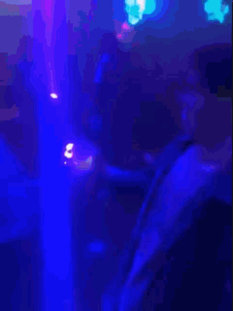 a blurry picture of a person 's face with purple and blue lights behind them