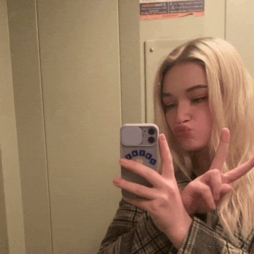a woman taking a picture of herself with a phone that has the word daboo on it