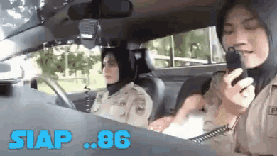 a woman is talking on a walkie talkie in a car .