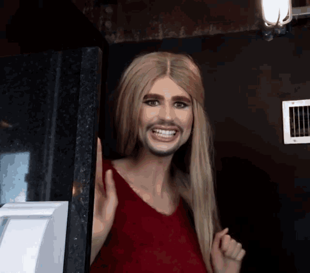 a woman with blonde hair and a beard smiles