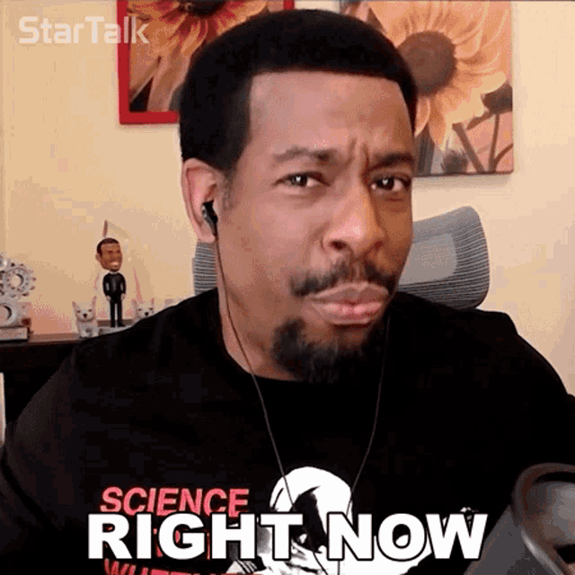 a man wearing ear buds and a science right now shirt
