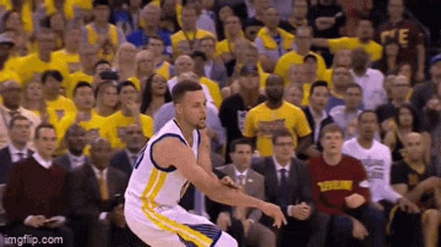 a basketball player in a golden state warriors uniform is jumping in the air in front of a crowd .