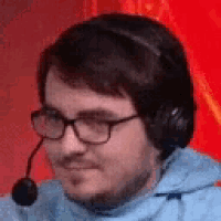 a man wearing glasses and headphones is smiling .