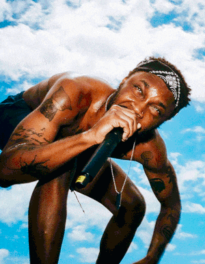a shirtless man is singing into a microphone