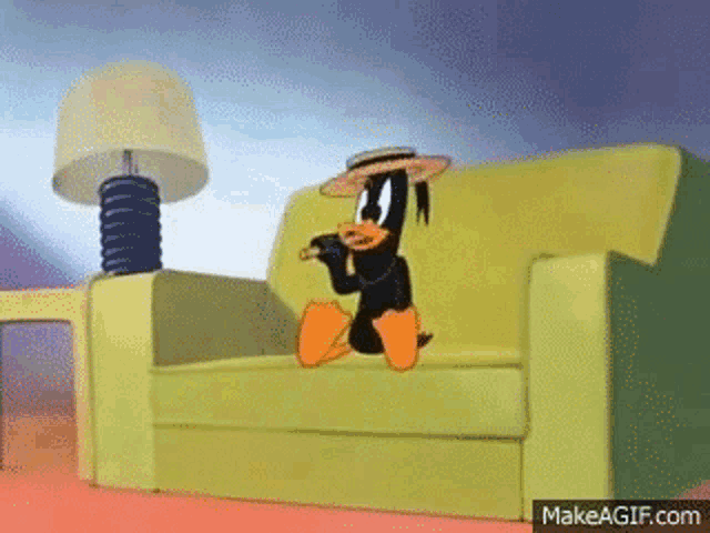 a cartoon duck is sitting on a couch smoking a cigar .