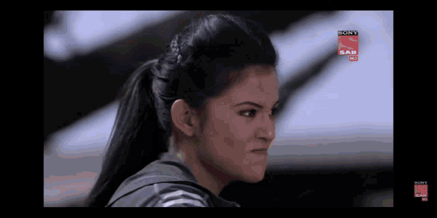 a woman in a ponytail is watching a sony sab hd channel