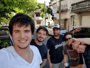 a group of young men are posing for a picture and one of them is wearing a shirt that says ' socal ' on it