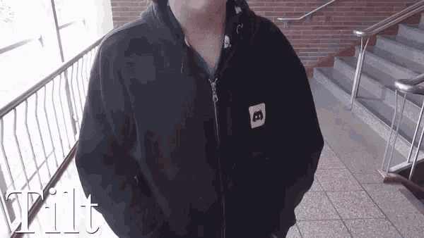 a person wearing a black jacket with the letter b on the sleeve
