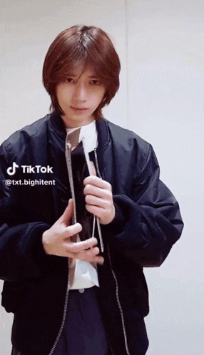 a man wearing a black jacket and a white shirt has tiktok written on the bottom right