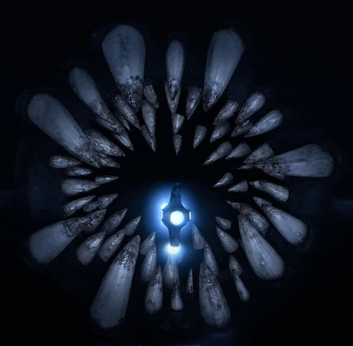a blue light is shining through a circle of sharp objects