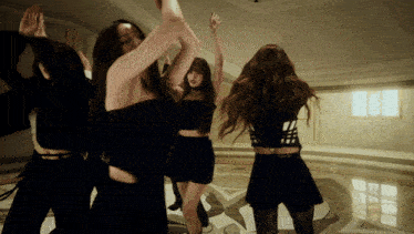 a group of women are dancing in a room