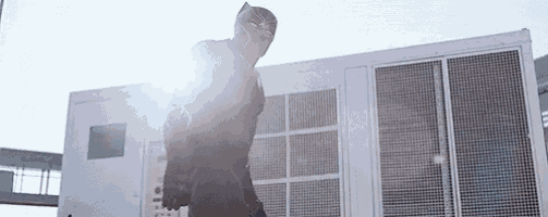 a man in a black panther suit is standing in front of a white building .